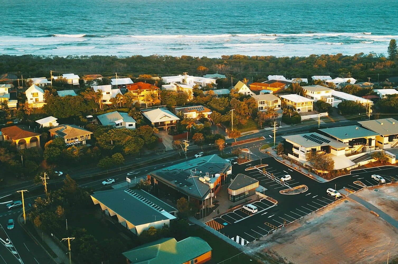 Aerial view of the Peregian Digital Hub and Peregian Beach village, with the ocean behind